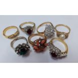 A group of 7 gold tone and silver tone dress rings in different styles with various coloured paste