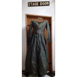 A Victorian ladies hand-made silk dress in dark green having 3 horizontal black lace panels to the