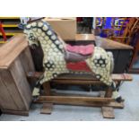 A large early 20th century painted wooden rocking horse with a mane saddle and tail, on a swing base