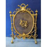 A late 19th Century French brass firescreen in the Rococo style with winged cherubs centred on a
