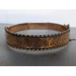 A gold coloured bracelet with engraved ornament, tested as gold, 107g Location: