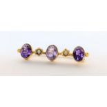 A yellow metal brooch having three amethyst's and two seed pearls, 3g Location: