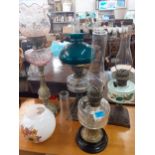 Four Victorian oil lamps with 4 glass funnels, glass and ceramic reservoirs, and 3 shades one A/F