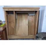 An early 20th century French pine triple wardrobe with panelled doors, on turned feet 196cm h x