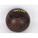 A reproduction of an early 20th century stitched brown leather football Location: