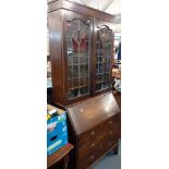 An early 20th century oak bureau bookcase with lead glazed doors, a fall front and three drawers,