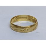 An 18ct gold wedding band with leaf engraved decoration, 3.3g Location: