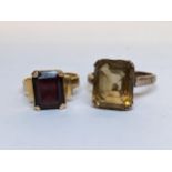 Two rings to include a yellow metal citrine set ring and a yellow metal garnet set ring, 7.9g