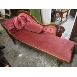 A Victorian mahogany chaise longue upholstered in a pink dralon on turned legs and castors (one