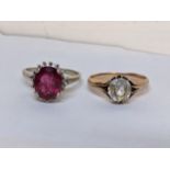 A 14ct white gold ring inset with a red stone, together with a yellow metal ring inset with a