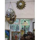 A Metamee quartz Sunburst clock, a gilt framed wall mirror, bevelled glass and fabric tassels, and a