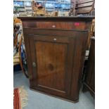 A Georgian oak wall hanging corner cabinet having single panelled door and fitted shelves, 104.5cm h