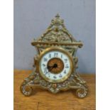 A late 19th century French brass cased clock having an enamel chapter ring, scroll shaped feet and
