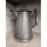 A Victorian pewter water jug having a grape shaped finial, gadrooned rim and scroll shaped handle