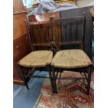 A pair of Arts & Crafts mahogany chairs having rush seats and ring turned supports Location: