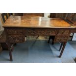 An early 18th century oak desk with later carved decoration having five drawers and on block