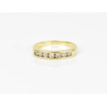 An 18ct yellow gold and diamond half eternity ring, with seven channel set round brilliant cut