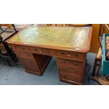 An early 20th century walnut twin pedestal desk having a green leather scriber and nine drawers,