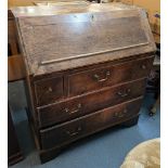 A Georgian oak bureau having a fall flap with fitted interior above three short and two long