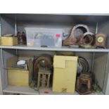 Two shelves of various clock cases and parts, for spares and repairs to include car clocks, mantel