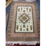 A hand woven beige ground Moroccan rug having a central motif with geometric design, 183cm x 124cm