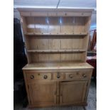 A Victorian pine dresser having a plate rack above three drawers and two cupboard doors, 193cm h x