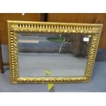 A 20th century gilt wood swept frame with pierced ovals, raised leaf and bead decoration, bevelled