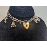 A 9ct gold curb-link charm bracelet, having seven 9ct gold charms and a heart-shaped padlock