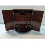 A 20th century mahogany smokers cabinet having a fitted interior with two cupboard doors, 45h x 37w