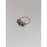 A gold and white metal ring set with three sapphires 0.36 to 0.65ct, each surrounded by diamonds