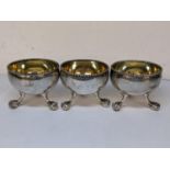 Three Victorian silver salts engraved with initials and raised on ball and claw feet, 1879