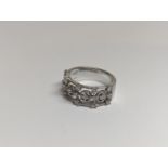 A designer 18ct white gold ring inset with 19 diamonds in a pierced setting 6.4g, along with a