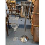 A modern Champagne/wine bucket on a stand together with an oversized glass Location: