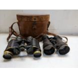 Two binoculars to include an early 20th century Bausch & Lamb military issue pair in a leather