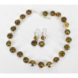 A silver and green amber bead necklace with matching earrings, the amber beads with silver surround,