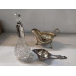 Silver to include a sauce boat on splayed feet, a tea strainer and scent bottle with a silver collar