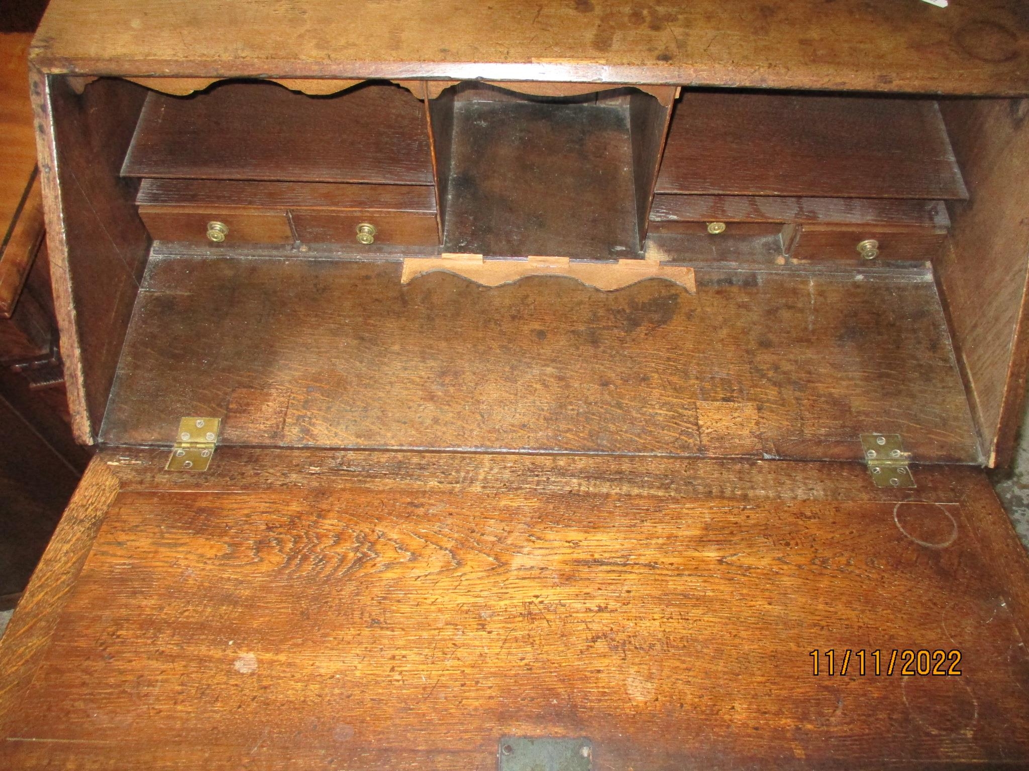 A Georgian oak bureau, fall flap revealing a pigeonhole interior with drawers over two short - Image 2 of 2