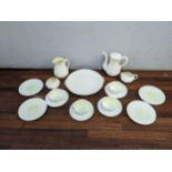 A Belleek cream glazed coffee/tea set of shell design comprising four cups and saucers, a coffee