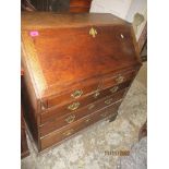 A Georgian oak bureau, fall flap revealing a pigeonhole interior with drawers over two short