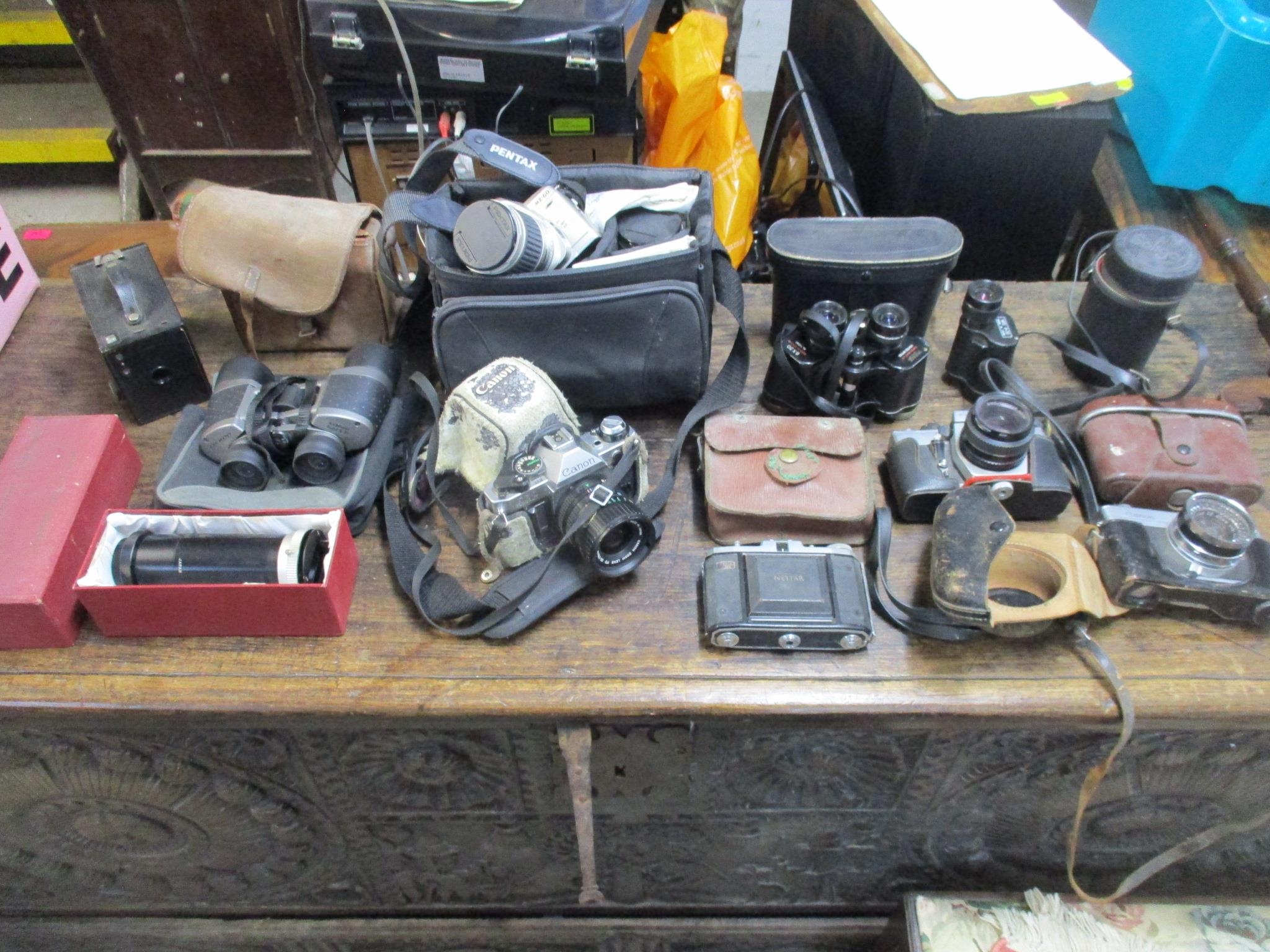 A selection of vintage film cameras, camera accessories, and cased binoculars to include a Nettar