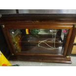 A modern mahogany display cabinet with glazed front flanked by fluted pilasters with brass capitals,