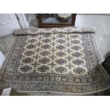 A hand woven Bukhara Pakistan rug decorated with geometrical motifs on a cream ground and multiguard