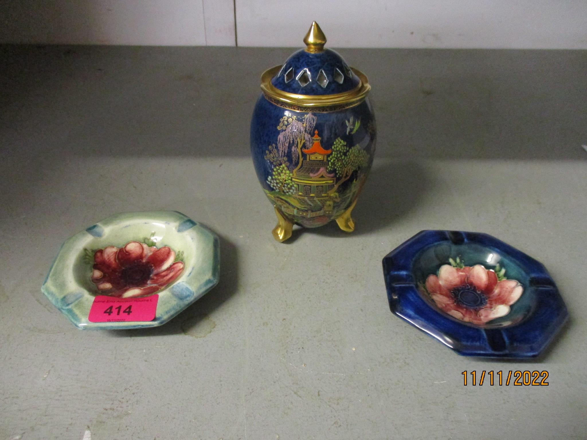 Two Moorcroft pottery ashtrays decorated with an anemone design, one on a navy blue ground, the