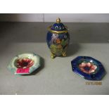 Two Moorcroft pottery ashtrays decorated with an anemone design, one on a navy blue ground, the