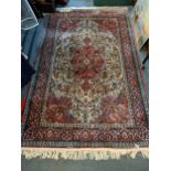 A hand woven red ground rug having a central medallion and geometric designs, 192cm x 126cm