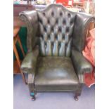 A reproduction green leather wing back armchair Location: A4B