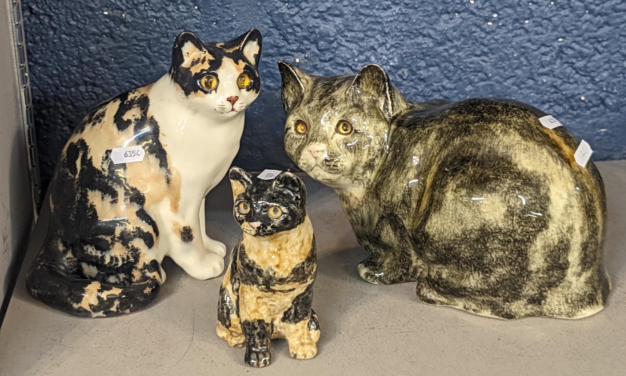 A group of three English pottery cats signed I Winstanley, the tallest 21cm Location:
