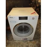 A Miele W1 Twin DOS and WiFi connect washing machine with spanner to release the drum Location: