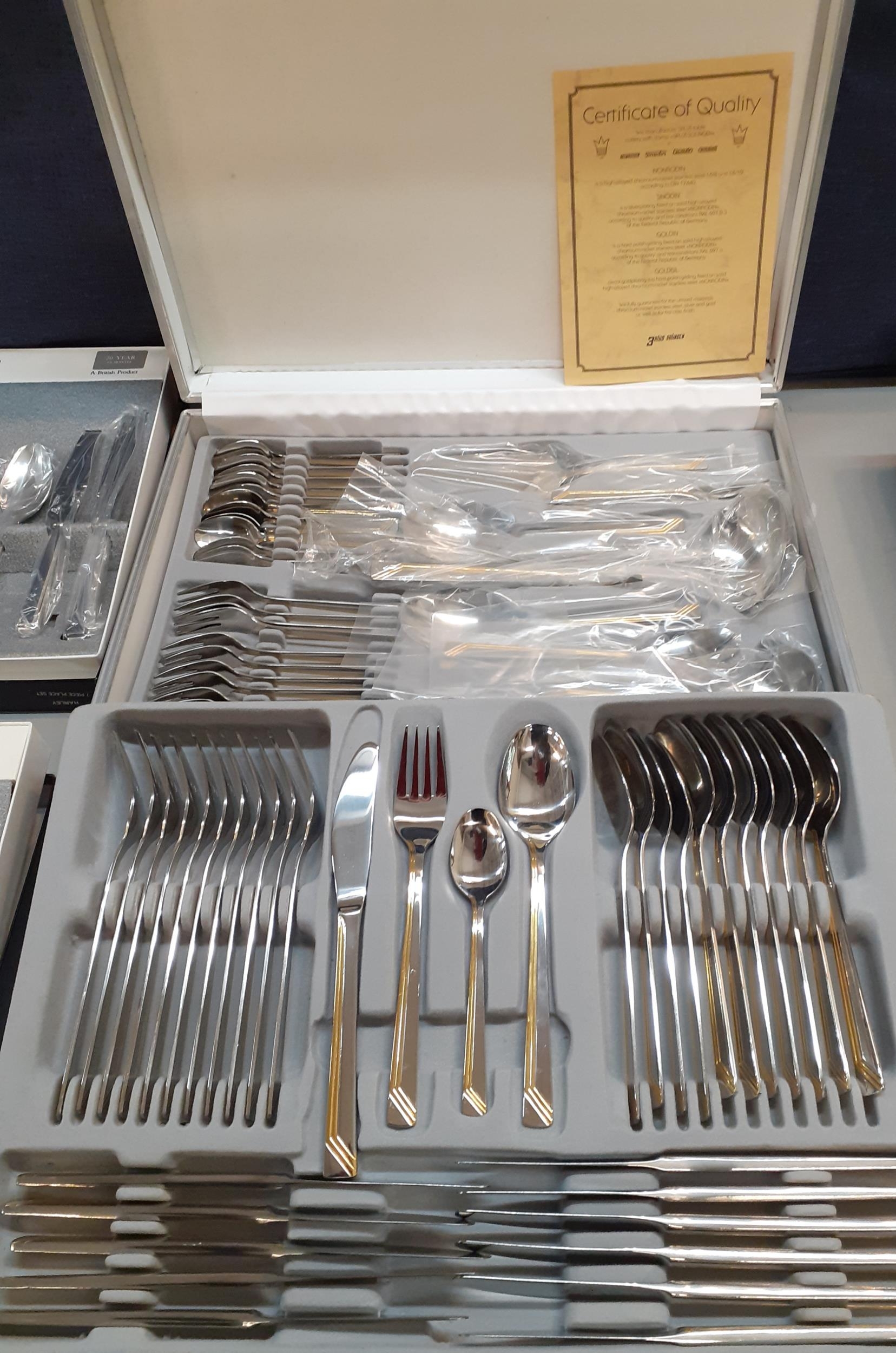 An SBS Bestecke Solingen 12-setting cutlery set in a gold and silver colour housed in a silver