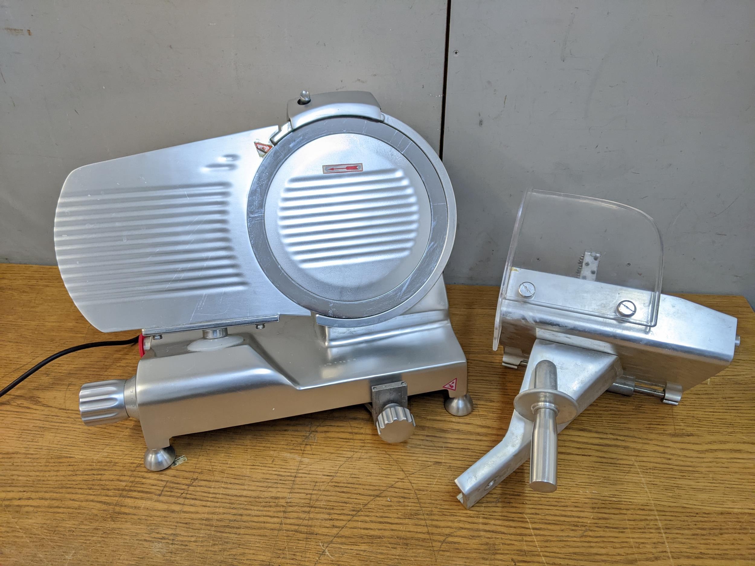 A metal electric meat slicer with a continental plug Location: